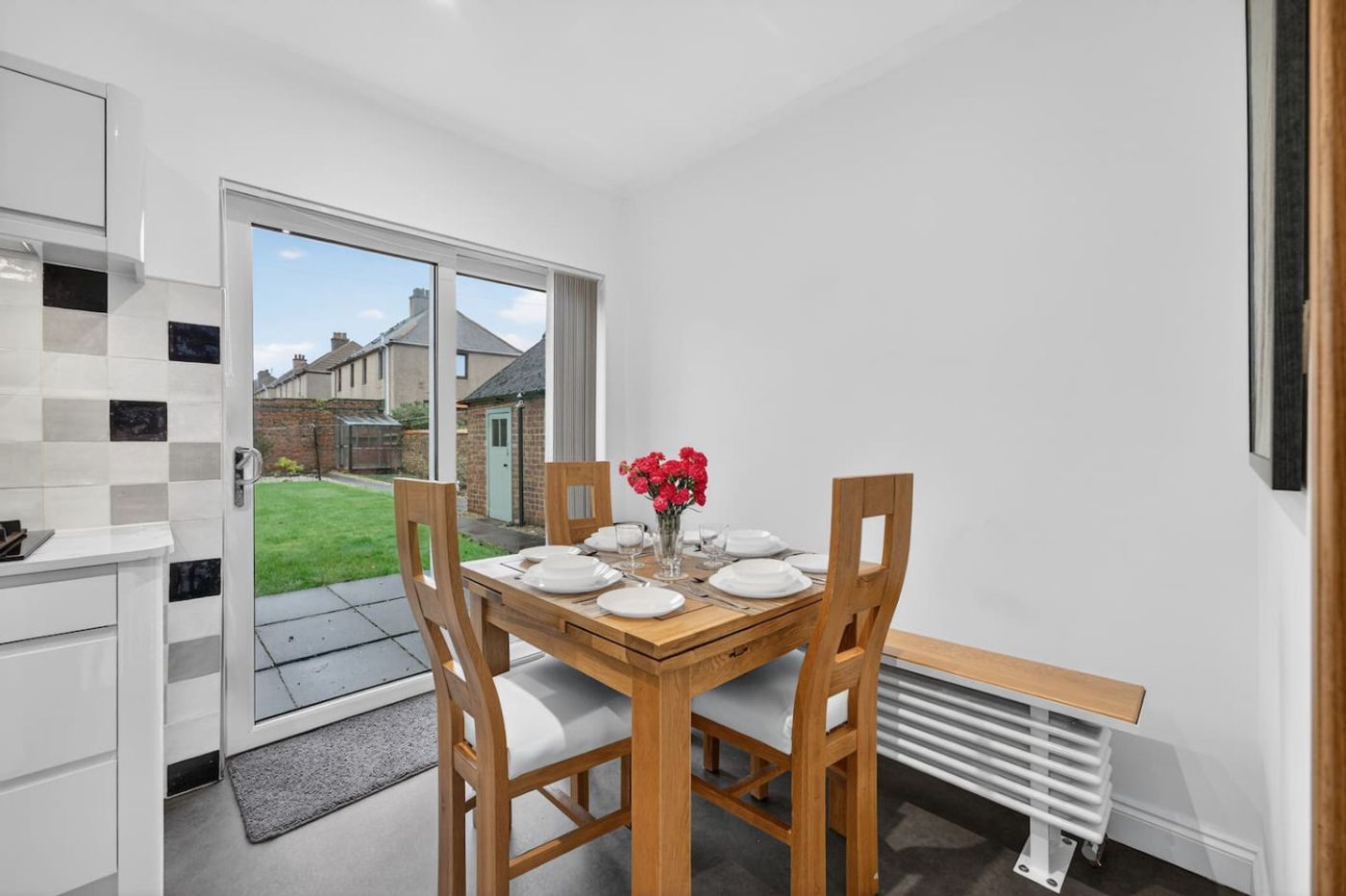 Dining table set for four, garden through the sliding door.