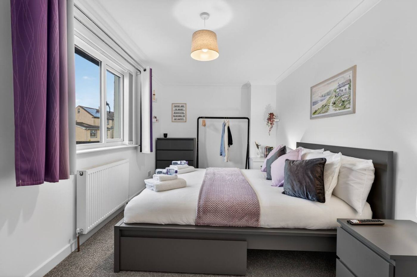 The second bedroom, grey bed and purple curtains.