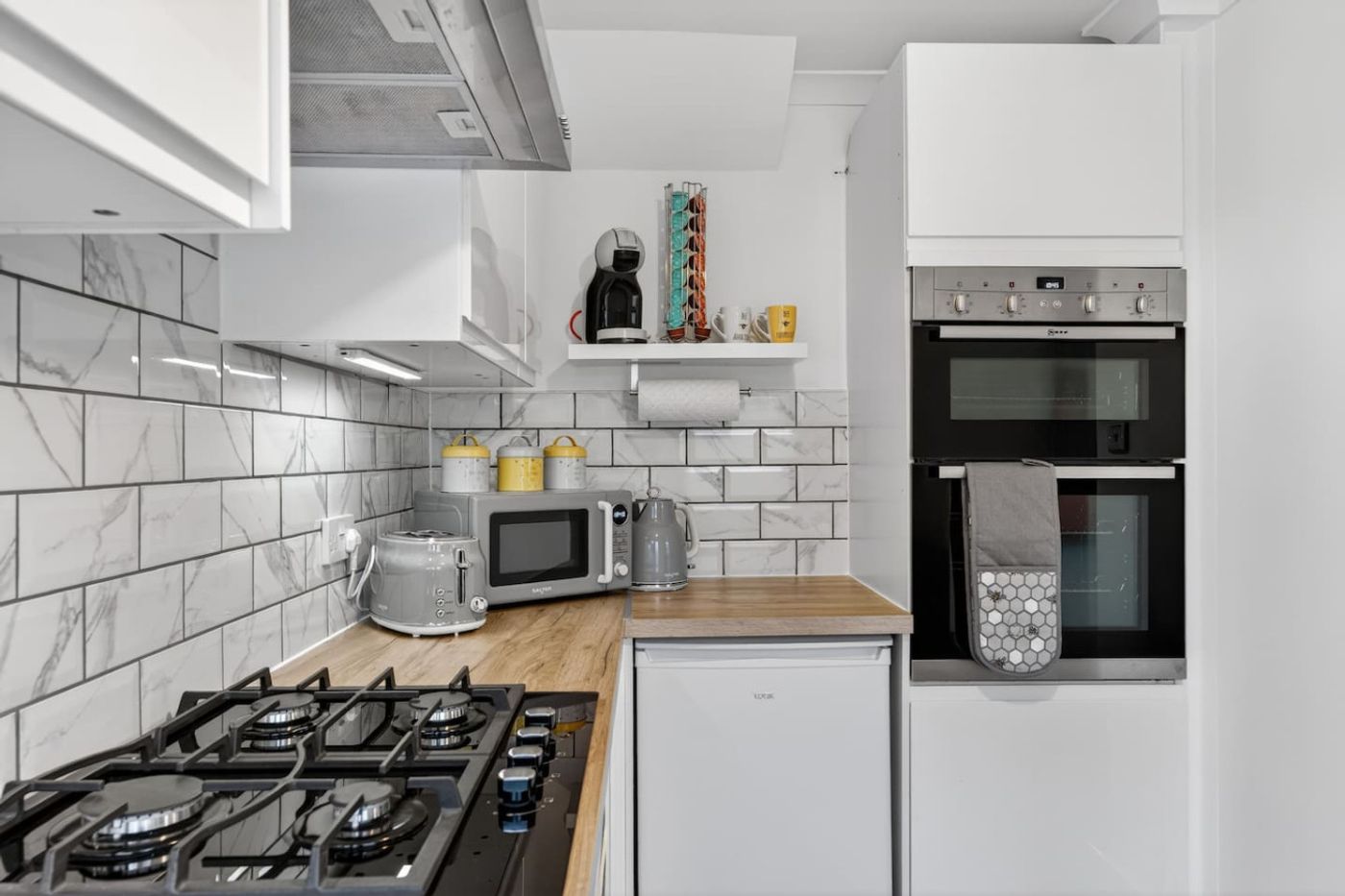 Kitchen hob, oven, and coffee things.